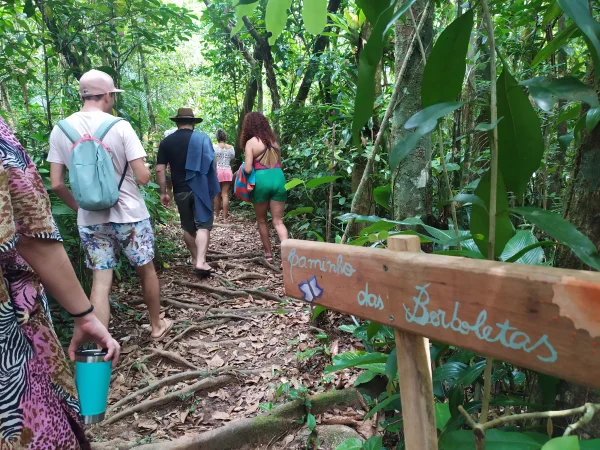 Grupo em caminhada por uma trilha na floresta