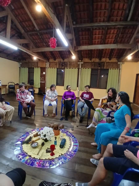 Roda de conversa no salão, com uma mandala de flores montada no chão