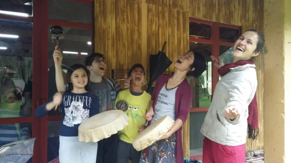 Grupo tocando pandeiro e cantando dentro do salão de madeira